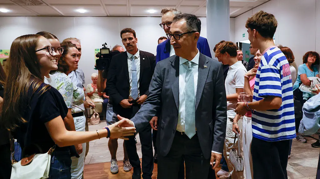 Der Ministerpräsident Cem Özdemir begrüßt eine junge Frau