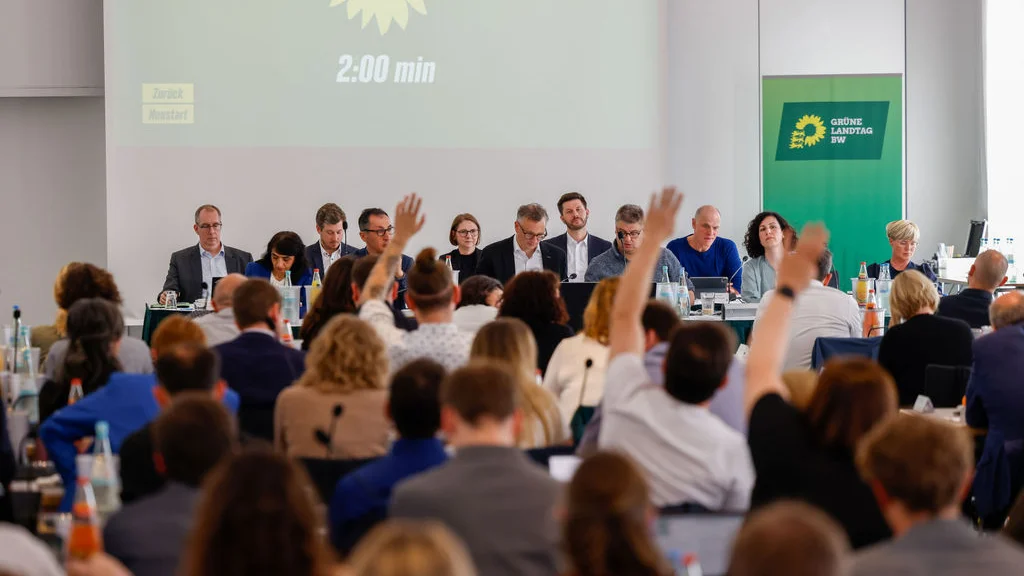 Die Abgeordneten heben ihre Hand zu Abstimmung.