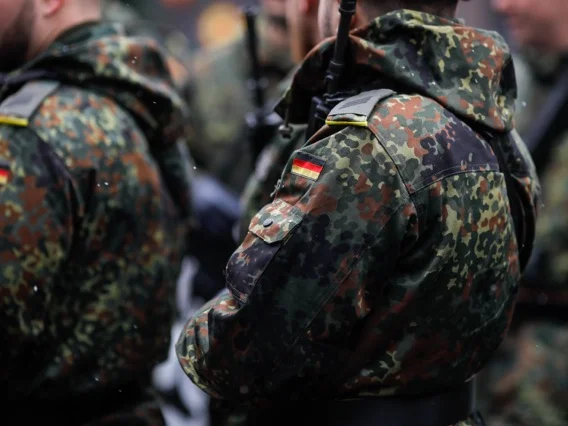 Menschen stehen bekleidet in der Bundeswehr-Uniform nebeneinander. 