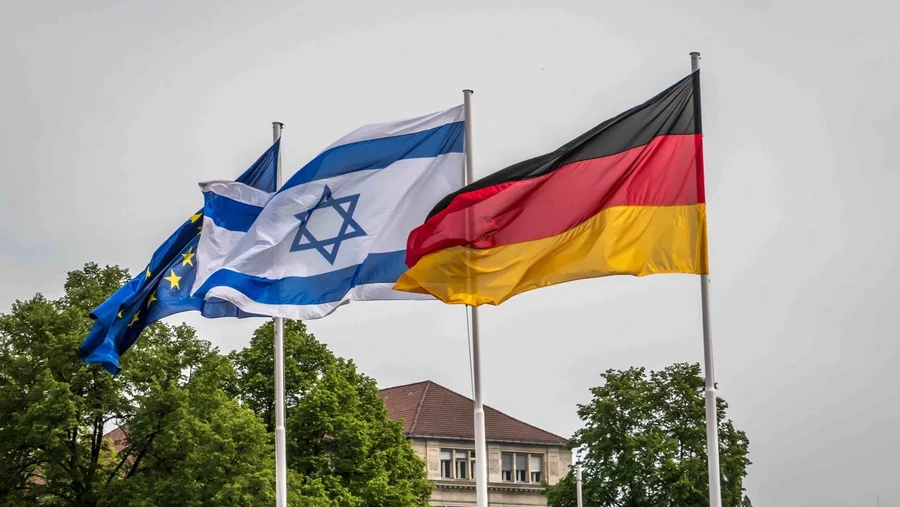 Die EU-, die israelische und die deutsche Fahne wehen im Wind.