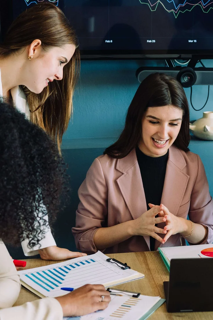 Junge Studierende arbeiten an einem StartUp-Konzept in einem Uni-Raum.