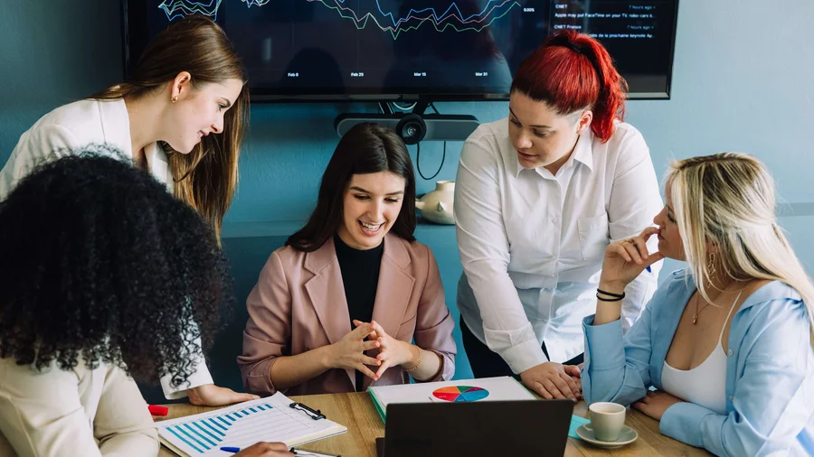 Junge Studierende arbeiten an einem StartUp-Konzept in einem Uni-Raum.