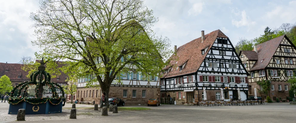 Blick auf geschmückten Brunnen und Fachwerkhäuser.