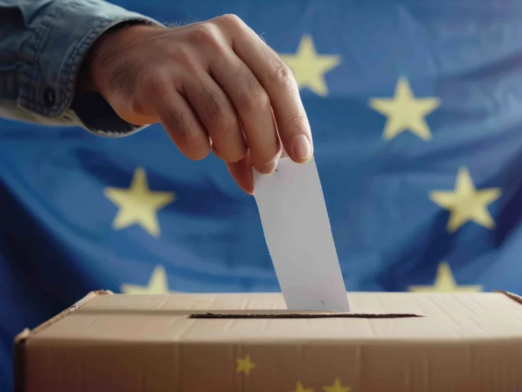 Jemand wirft einen Stimmzettel in die Wahlurne zur Europawahl.