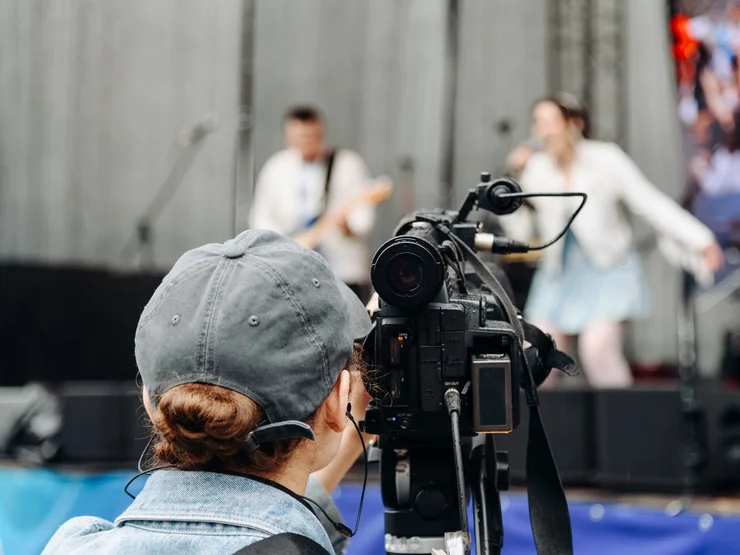 Eine Frau filmt eine Konzert.