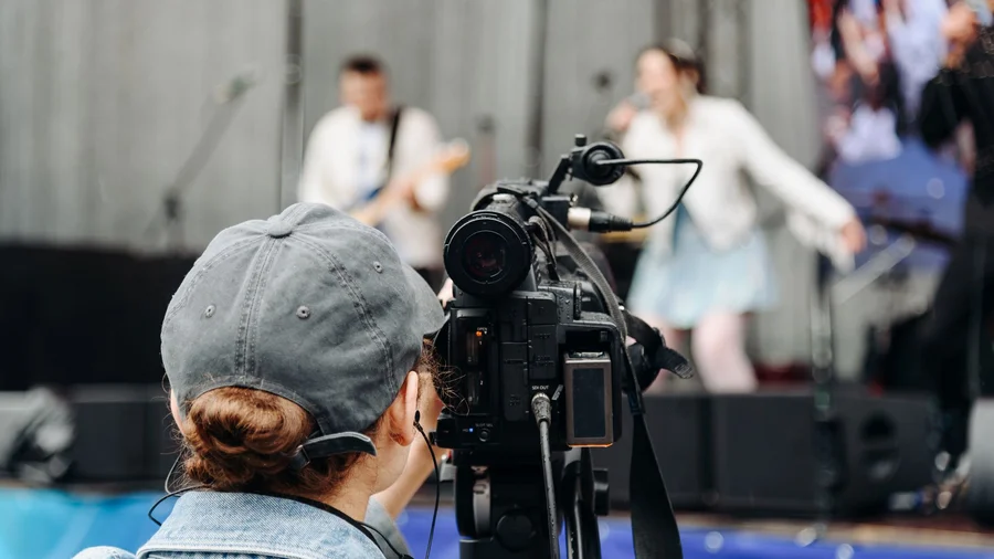 Eine Frau filmt eine Konzert.
