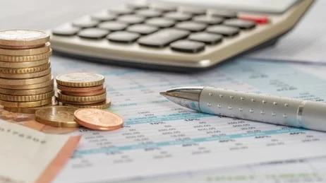 Geldscheine, Münzen, Taschenrechner, Stift.