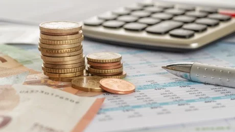 Geldscheine, Münzen, Taschenrechner, Stift.