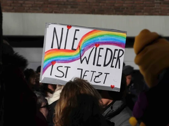 Jemand hält auf einer Demo das Schild "Nie wieder ist jetzt" hoch.