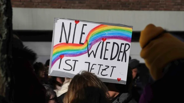 Jemand hält auf einer Demo das Schild "Nie wieder ist jetzt" hoch.