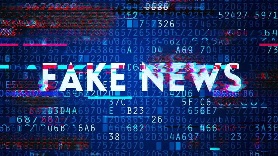 Bildschirm mit Zahlen und Buchstaben und dem Schriftzug "Fake News".