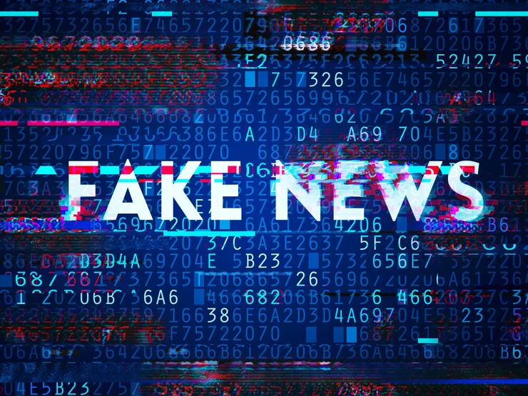 Bildschirm mit Zahlen und Buchstaben und dem Schriftzug "Fake News".