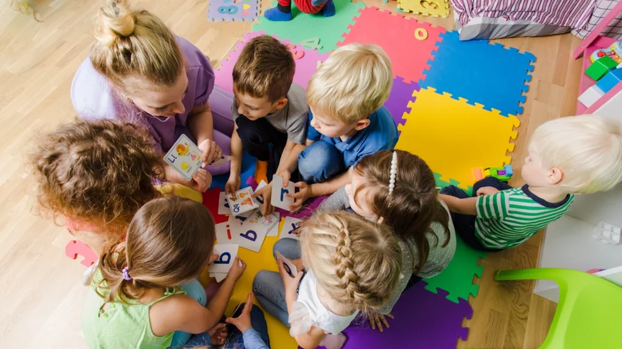 Kinder spielen mit Buchstaben-Karten.