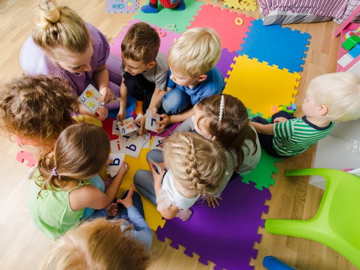 Kinder spielen mit Buchstaben-Karten.