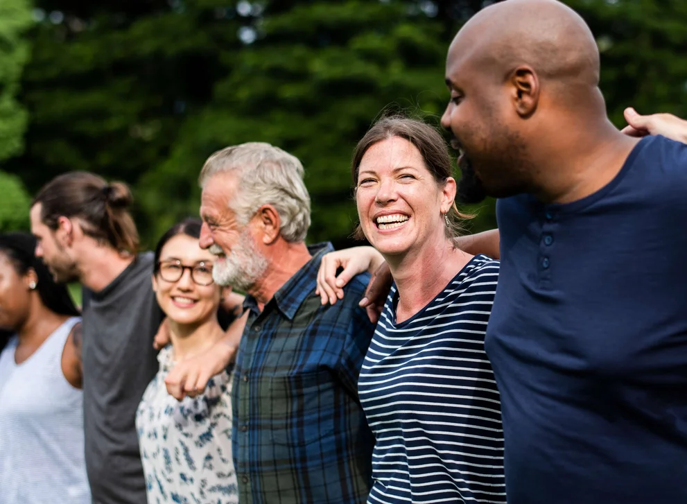 Diverse Menschengruppe stehen nebeneinander und freuen sich.