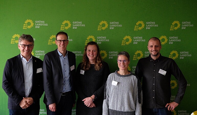 Foto vor grüner Wand mit 5 Personen