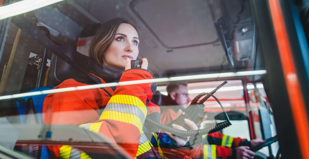Feuerwehrleute sitzen im Auto auf dem Weg zu einem Einsatz.