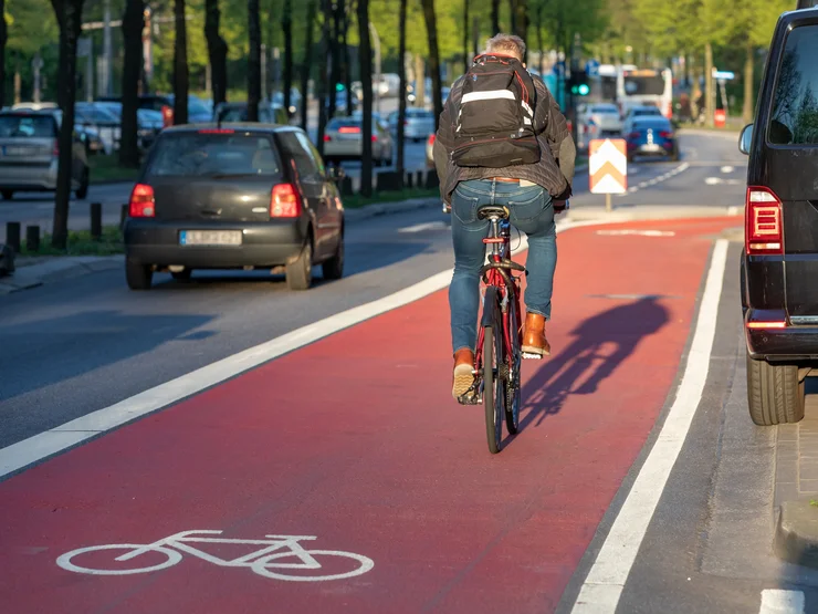 Ein Fahrradfahrer fährt auf einem rot gekennzeichneten Radweg.