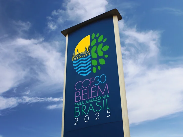 Vor blauem Himmel ist ein Plakat der Weltklimakonferenz in Belem zu sehen