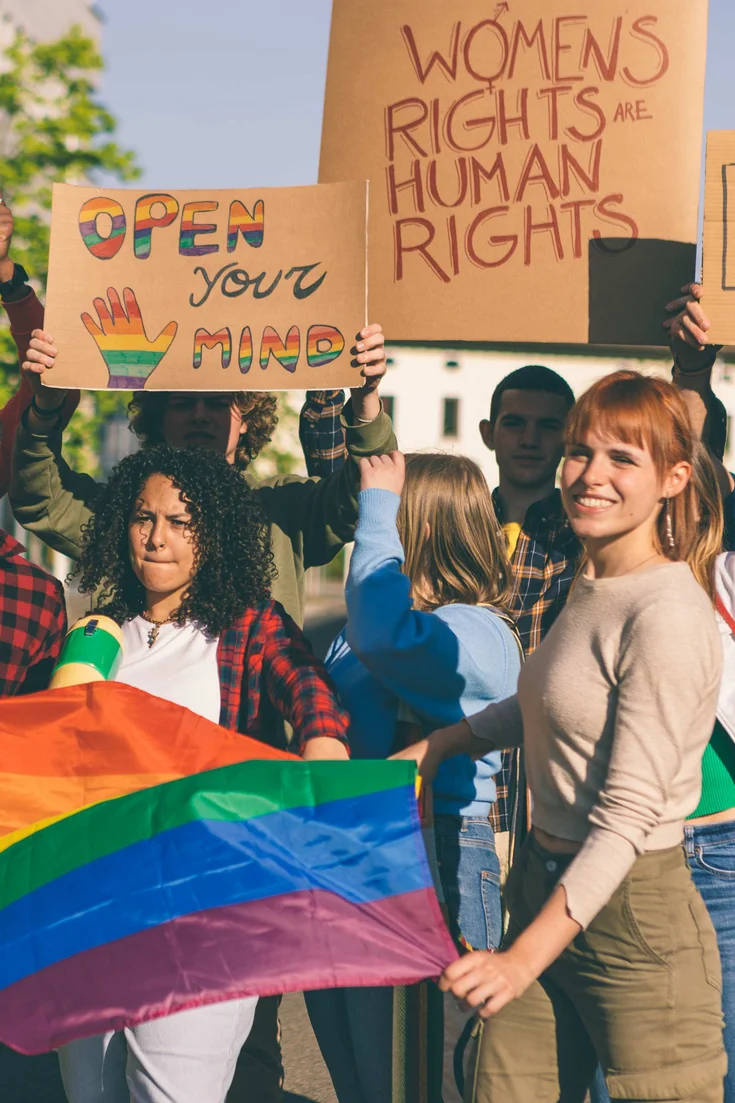 Eine diverse Gruppe von Aktivist:innen protestieren auf der Straße für gleiche Rechte.