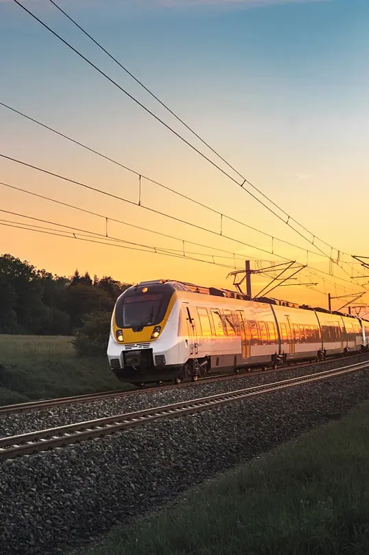 Eine Bahn auf der Schiene, im Hintergrund ein Abendhimmel.