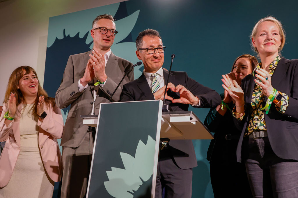 Cem Özdemir freut sich und formt mit seinen Händen ein Herz.